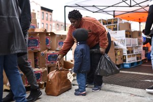 A woman and her child pick from a selection of donated food at the "Bed-sty Campaign Against Hunger" food pantry in the New York City borough of Brooklyn, NY, April 14, 2020.