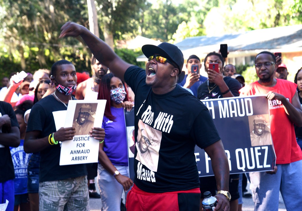 In this Tuesday, May 5, 2020, photo, Keith Smith speaks to a crowd as they march through a neighborhood in Brunswick, Ga. They were demanding answers regarding the death of Ahmaud Arbery. (Bobby Haven/The Brunswick News via AP)​