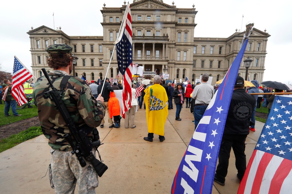 A protester carries his rifle at the State Capitol in Lansing, Mich., Thursday, April 30, 2020.