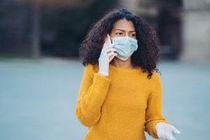 woman on cell phone in surgical mask pandemic