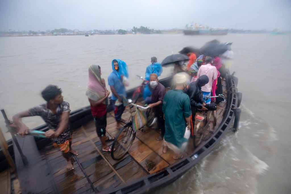 People cross the river before Cyclone Amphan hits Khulna, a coastal area in Bangladesh, on May 2