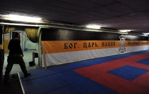 A picture taken on February 28, 2015 shows a member of the Russian Imperial Movement, a nationalist group in Russia, walking close to a banner reading "God.Tsar.Nation.We are Russians, God with us" at a training base in Saint Petersburg.