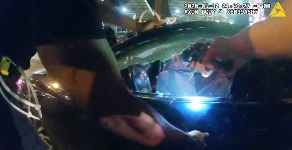 In this Saturday, May 30, 2020, photo taken from police body camera video released by the Atlanta Police Department, an officer points his handgun at Messiah Young while the college student is seated in his vehicle, in Atlanta. (Atlanta Police Department