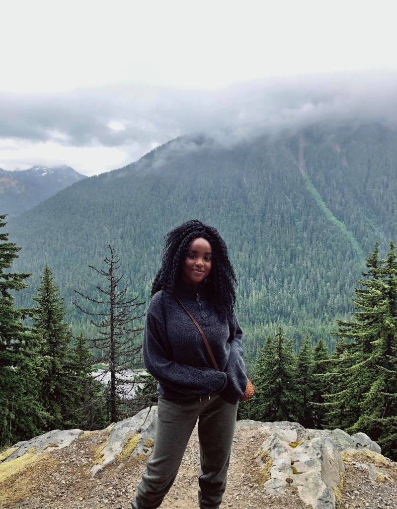 Black environmentalist Wanjiku Gatheru standing in the wilderness