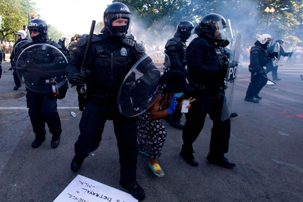 A demonstrator tries to pass between a police line wearing riot gear as they push back demonstrators outside of the White House, June 1, 2020 in Washington D.C., during a protest after the death of George Floyd.