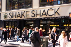 Pedestrians walk past an American fast casual restaurant chain, Shake Shack store in New York City.