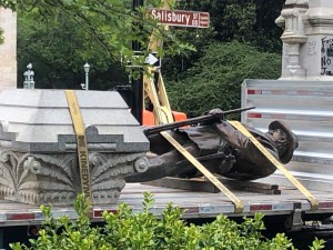 The statue of a Confederate soldier and plinth sit on a flatbed truck at the Old Capitol in Raleigh, N.C., on Sunday, June 21, 2020. After protesters pulled down two smaller statues on the same monument Friday, North Carolina Gov. Roy Cooper ordered the r