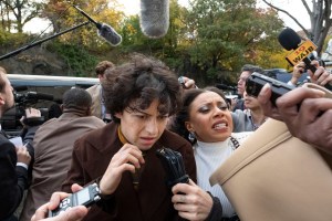 a still from season 3 of search party on hbo max showing alia shawkat and shalita grant surrounded by microphones and recorders outside a courthouse