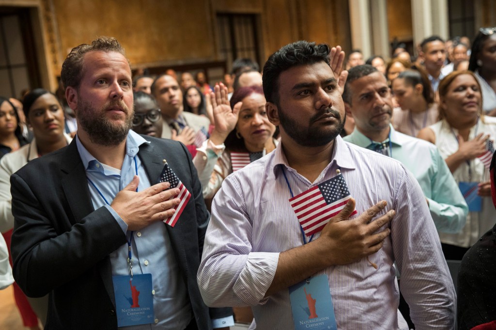 New U.S. citizens recite the Pledge of Allegiance during naturalization ceremony at the New York Public Library, July 3, 2018 in New York City.