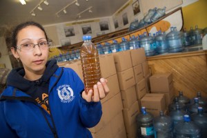 Potlotek resident holding dirty tap water