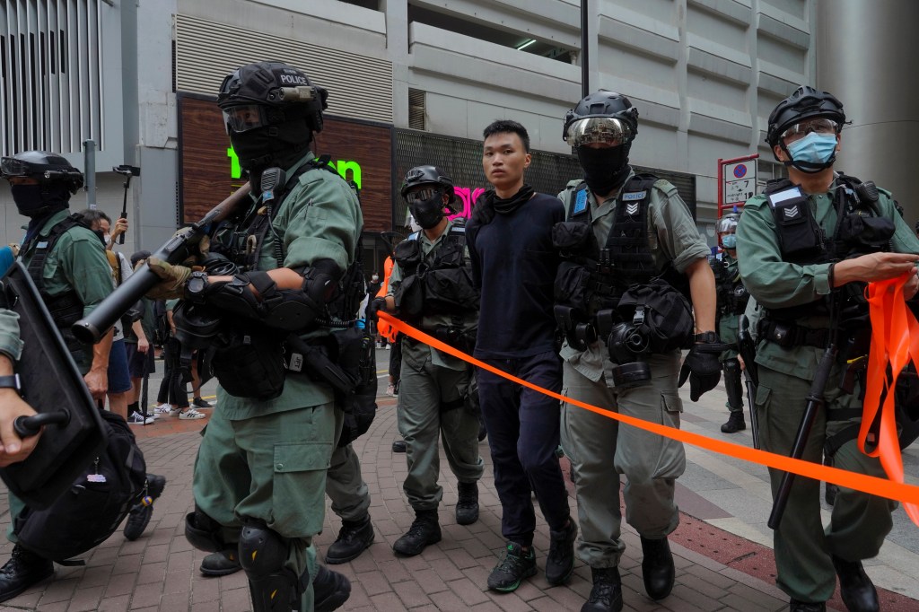 A protester is detained by riot police during the annual handover march in Hong Kong, Wednesday, July. 1, 2020. Hong Kong marked the 23rd anniversary of its handover to China in 1997, and just one day after China enacted a national security law that crack