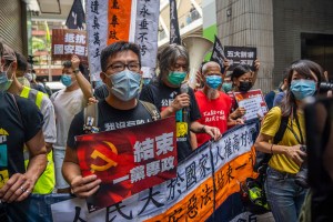 Demonstrators in Hong Kong hold placards and a banner while chanting slogans demanding the end of one party rule in China on July 2, 2020.