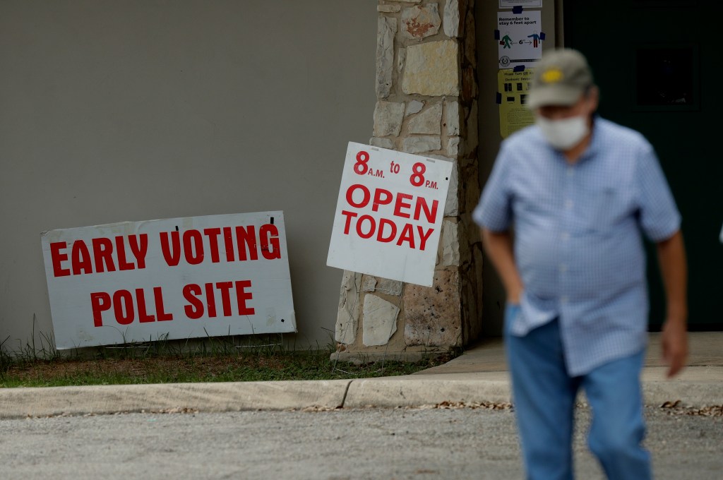 An early voter leaves a polling site, Tuesday, July 7, 2020, in San Antonio. Polling site workers are wearing masks and taking other precautions due to the COVID-19 outbreak. (AP Photo/Eric Gay)​