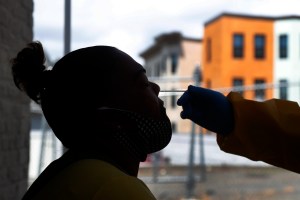 Evelinda Villegas receives a COVID-19 test at the Whittier Street Health Center's mobile test site, Wednesday, July 15, 2020, in Boston's Dorchester section. (AP Photo/Elise Amendola)​