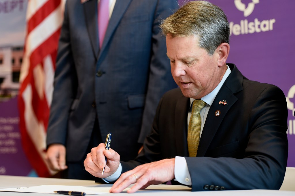 Georgia Gov. Brian Kemp signs House Bill 521 at Wellstar Kennestone Hospital, Thursday, July 16, 2020, in Marietta, Ga.