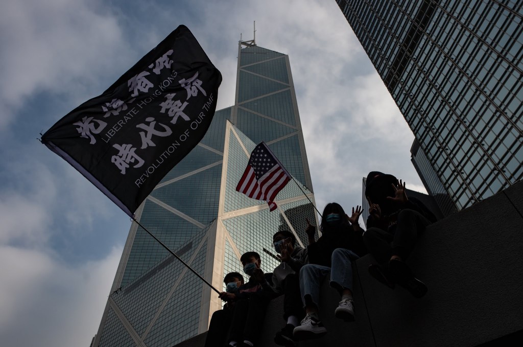 Pengunjuk rasa Hong Kong mengibarkan bendera bertuliskan “Bebaskan Hong Kong, Revolusi Zaman Kita”