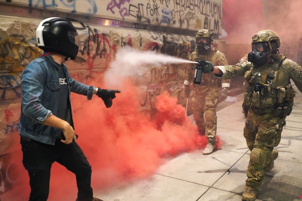 A federal officer pepper sprays a protester in front of the Mark O. Hatfield U.S. Courthouse on July 20, 2020 in Portland, Oregon.