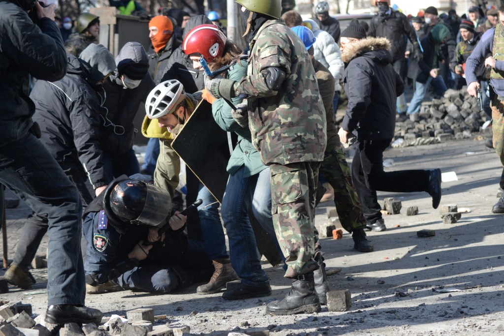 A police officer attacked by protesters during clashes in Ukraine in 2014. (Kyiv​Mstyslav Chernov​/Wikimedia Commons)