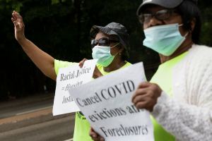 Annie Gordon, left, and Jenny Clark, rally for protection from evictions Saturday, June 27, 2020, in the Mattapan neighborhood of Boston. Massachusetts' tenant eviction moratorium is slated to expire in mid-August.