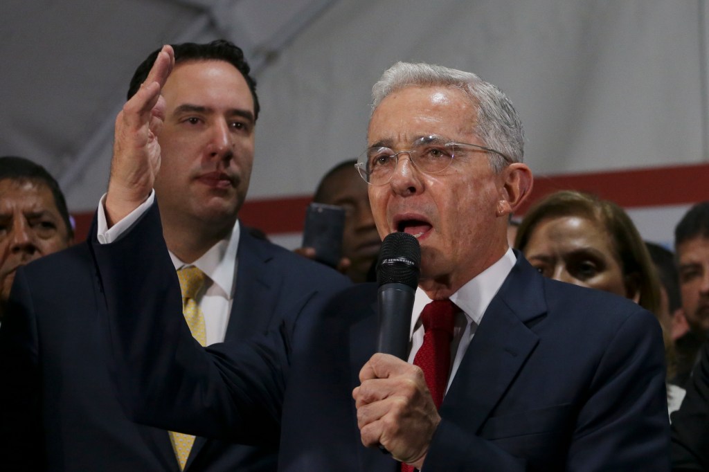 Former Colombian President Alvaro Uribe speaks to supporters gathered at the Democratic Center Party headquarters in Bogota, Colombia, Tuesday, Oct. 8, 2019. Uribe appeared before Colombia's Supreme Court on Tuesday for questioning in a case involving all