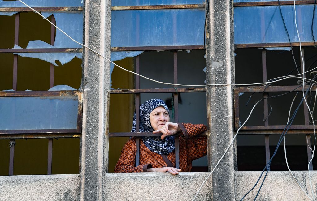 A woman looks out from a damaged building in a neighbourhood near the Beirut port.