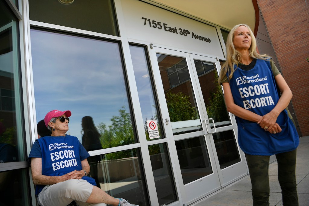 Volunteer escorts wait to assist incoming patients outside of the Planned Parenthood on July 18, 2019 in Denver, Colorado.