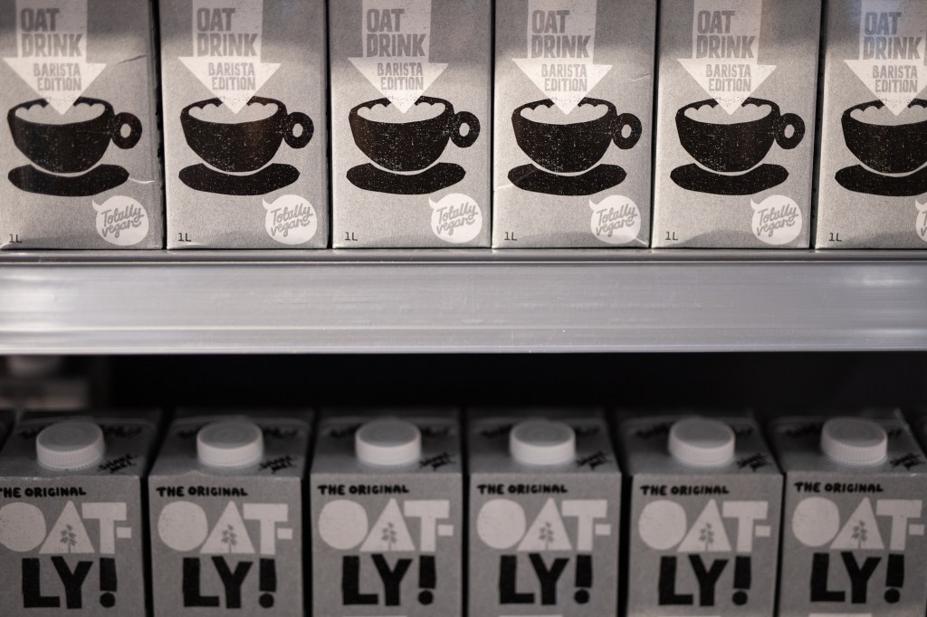 cartons of oatly non-dairy oat milk on a store shelf