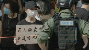 Protester holds a sign in front of a police line at a demonstration against Hong Kong's delayed Legislative Council election, Sept. 6, 2020. Photo by Mac Chau