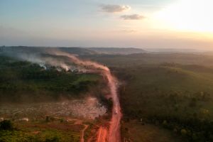 The red dust of the BR230 highway, known as "Transamazonica", mixes with fires at sunset in the agriculture town of Ruropolis, Para state, northern Brazil, on September 6, 2019.