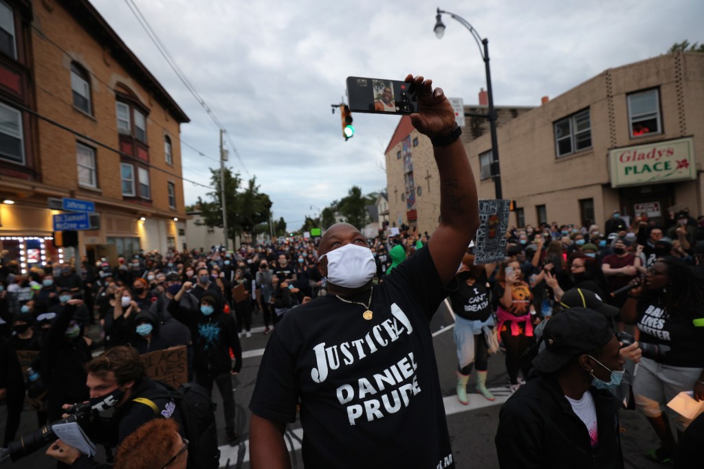 Joe Prude, the brother of Daniel Prude, holds up his phone at a march on September 05, 2020 in Rochester, New York.