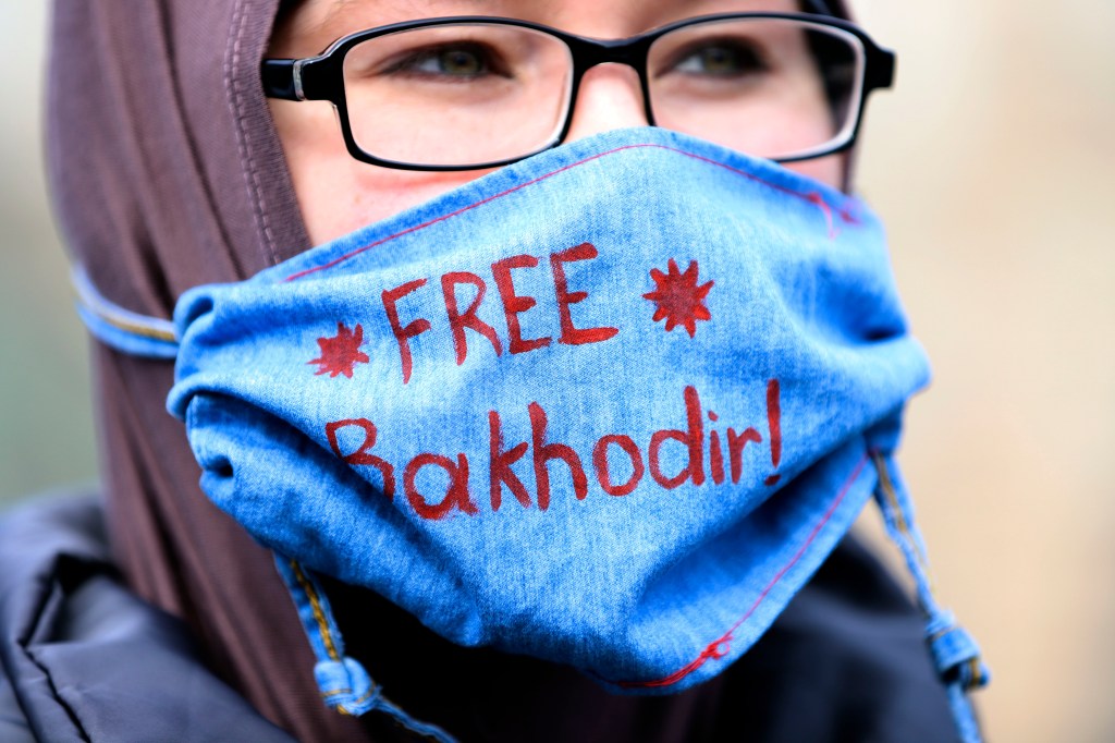 Madina Madjitov wears a mask that reads "Free Bakhodir" in Hartford, Conn., Thursday, April 2, 2020. Madjitiv's husband, Bakhodir Madjitov is currently in Immigration and Customs Enforcement custody. (AP Photo/Chris Ehrmann)