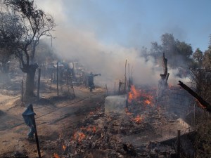 A fireman tries to put out a new small fire In the burned Moria refugee camp​.