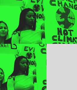 Young Black woman holding a "System Change, Not Climate Change" sign at a protest march