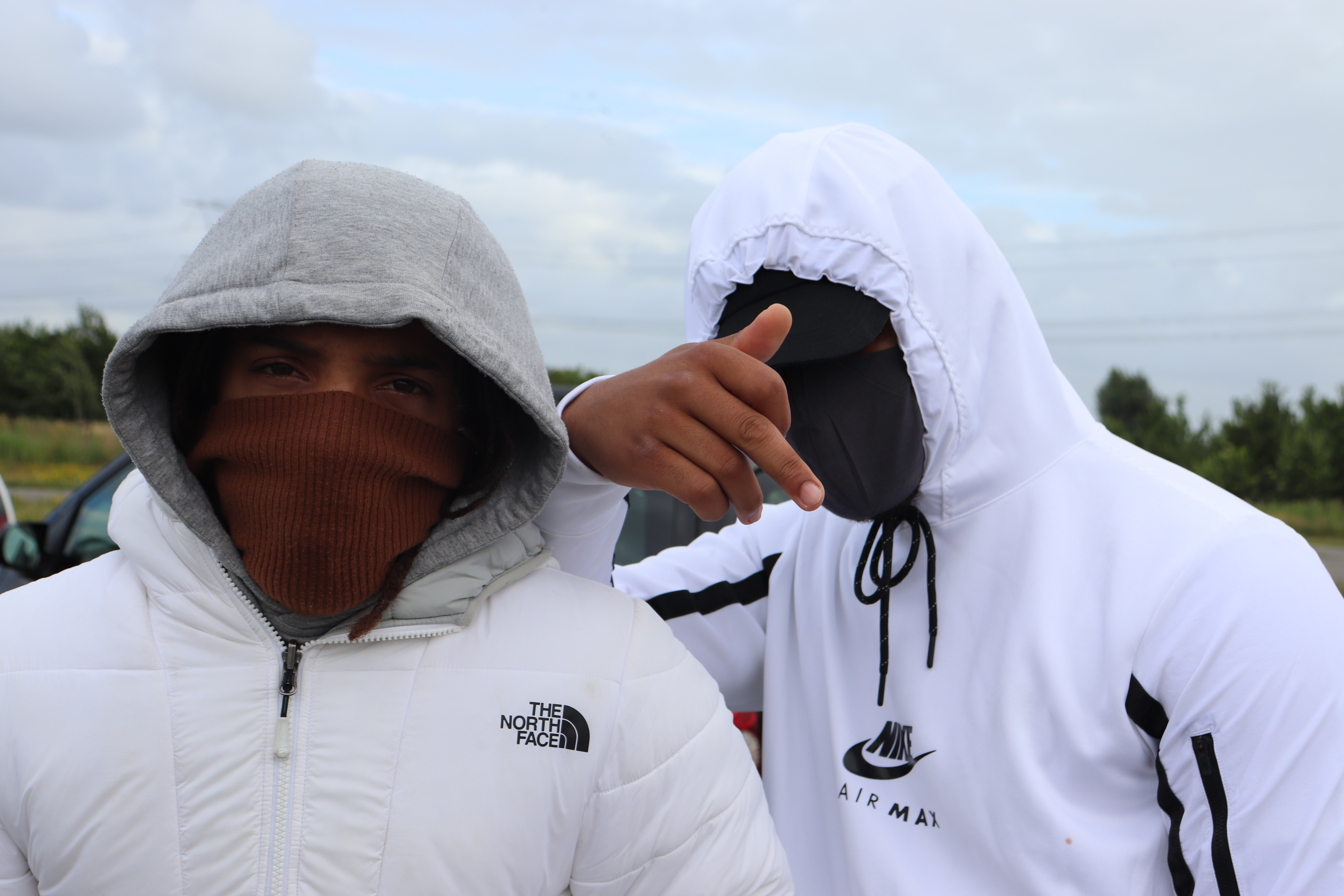 Two guys wearing masks and white hoodies.