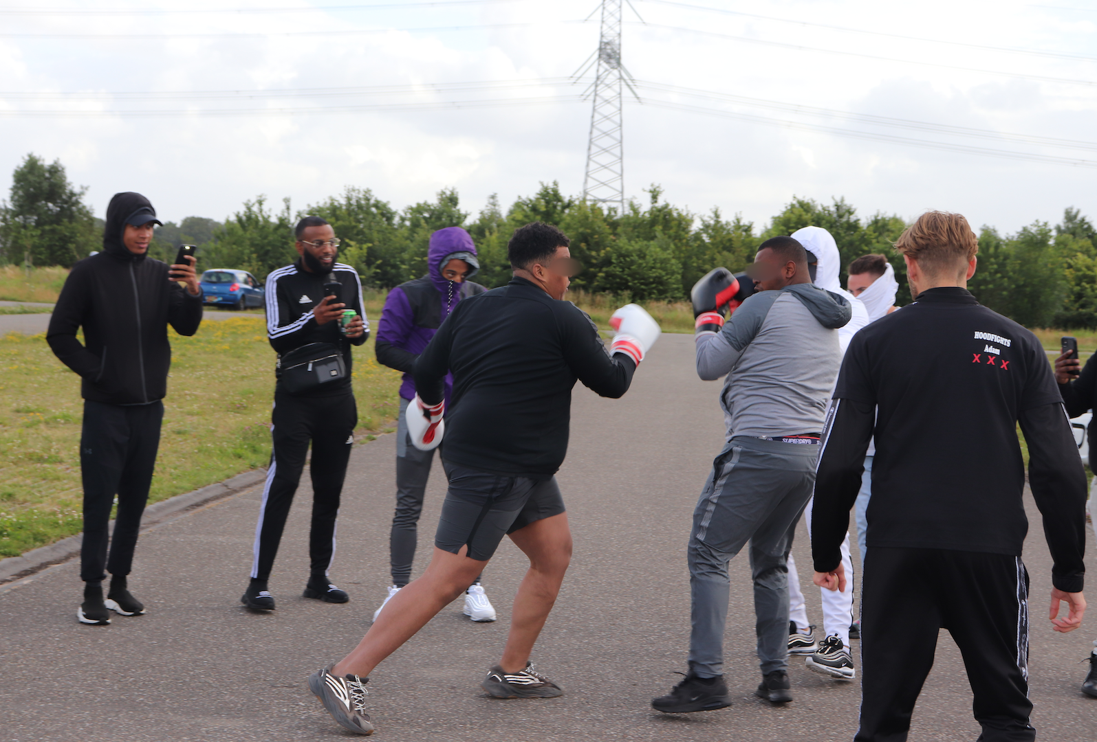 Choppa and VK fighting, surrounded by spectators filming them.