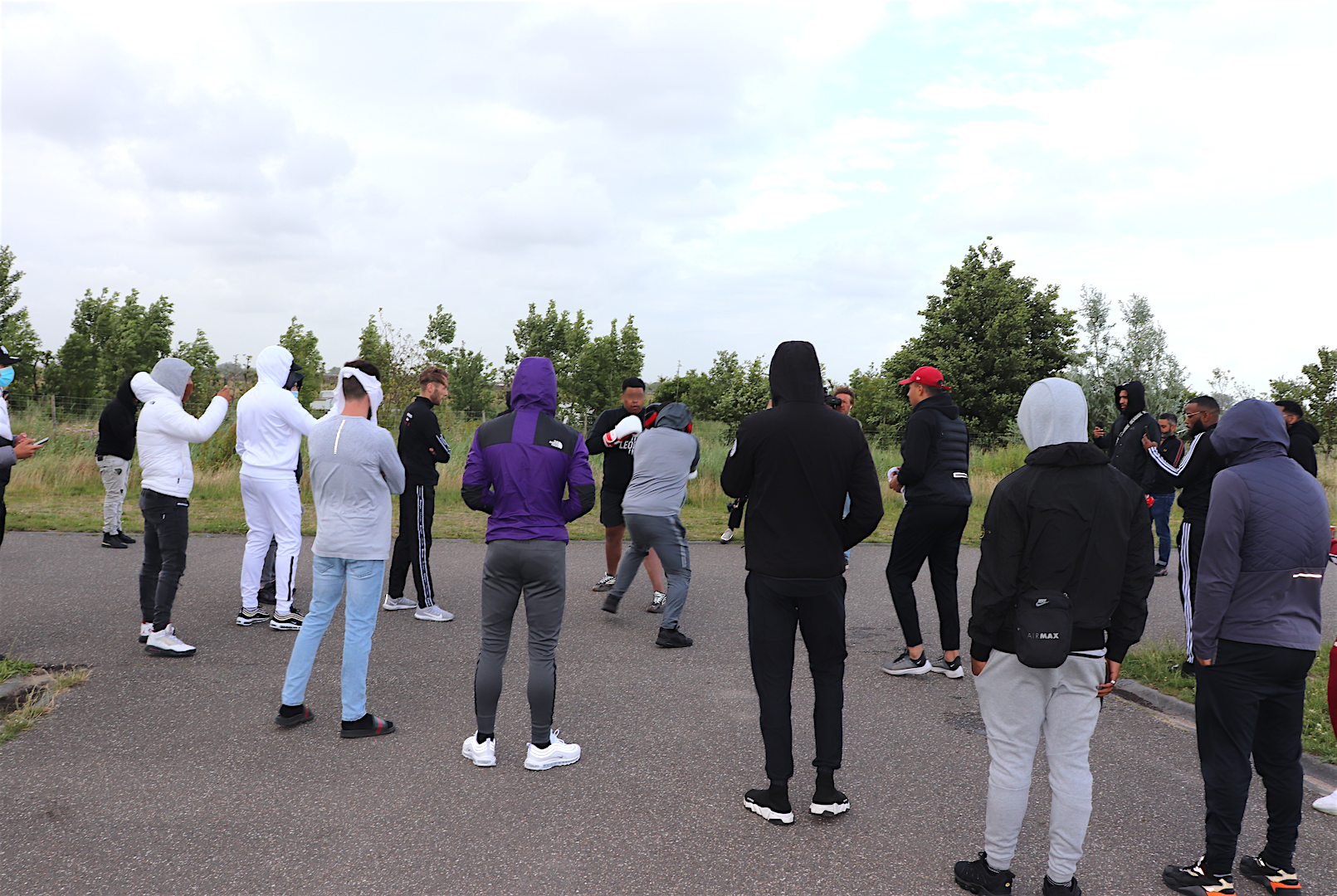 Spectators watching the fight in a circle.