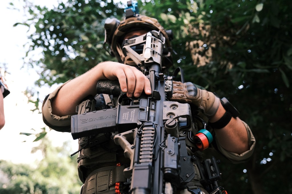 A man in full military gear poses for photo holding a gun during an open carry protest on July 4, 2020 in Richmond, Virginia.