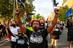 Protestors wearing Black Lives Matter t-shirts march outside