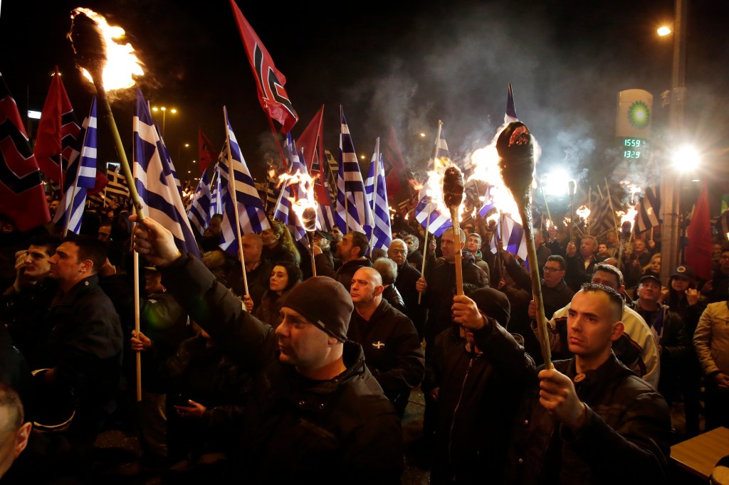 Supporters of Greece's far-right Golden Dawn party hold torches and wave national and party flags during a rally.