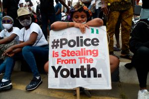 A girl sits during ongoing demonstrations to call for the scrapping of the controversial police unit SARS in Lagos.