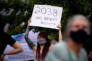 Eine FFF-Demonstrantin hält in Berlin ein Schild hoch, auf dem steht: 2038? Das reicht nicht