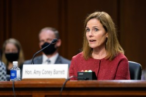 Supreme Court nominee Amy Coney Barrett speaks during a confirmation hearing before the Senate Judiciary Committee, Tuesday, Oct. 13, 2020, on Capitol Hill in Washington. Her family looks on at left.