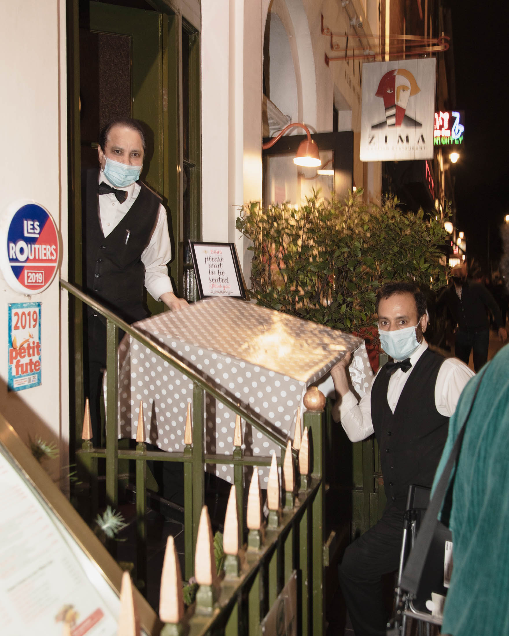 Waiters in Soho in London one the last night before new Tier 2 lockdown measures