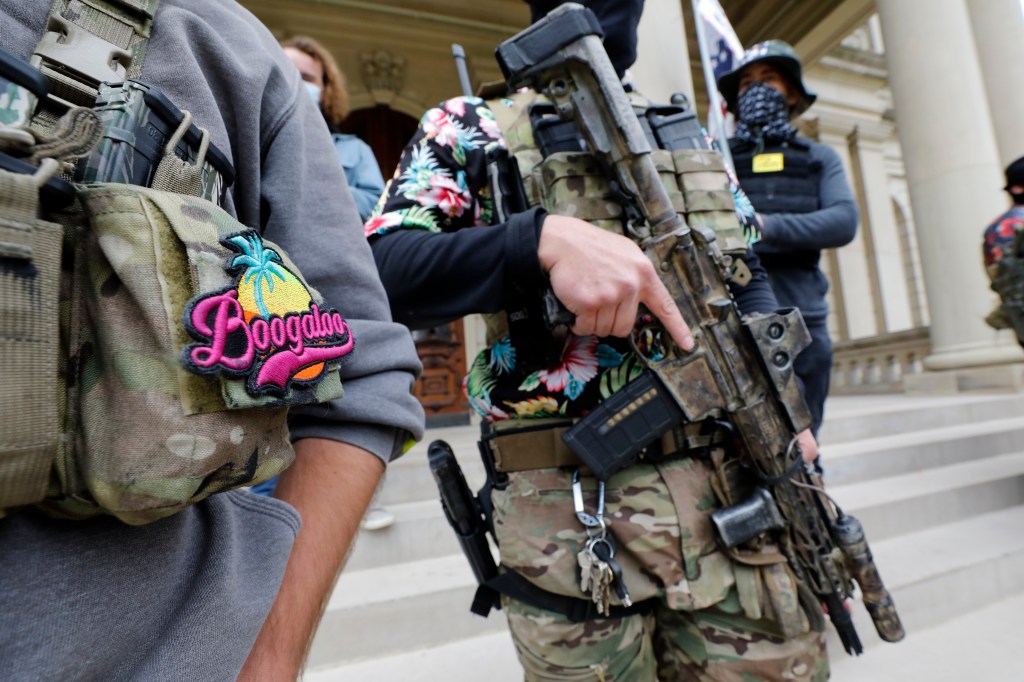 A group tied to the Boogaloo Bois holds a rally as they carry firearms at the Michigan State Capitol in Lansing, Michigan on October 17, 2020. (Photo by JEFF KOWALSKY / AFP) (Photo by JEFF KOWALSKY/AFP via Getty Images)