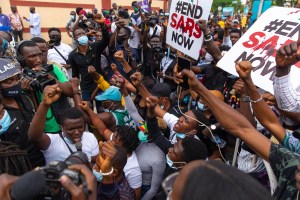 PROTESTERS RAISE THEIR FISTS TO RECITE THE NIGERIAN NATIONAL ANTHEM IN FRONT OF LAGOS’S HOUSE OF ASSEMBLY GATE ON OCTOBER 9, 2020.