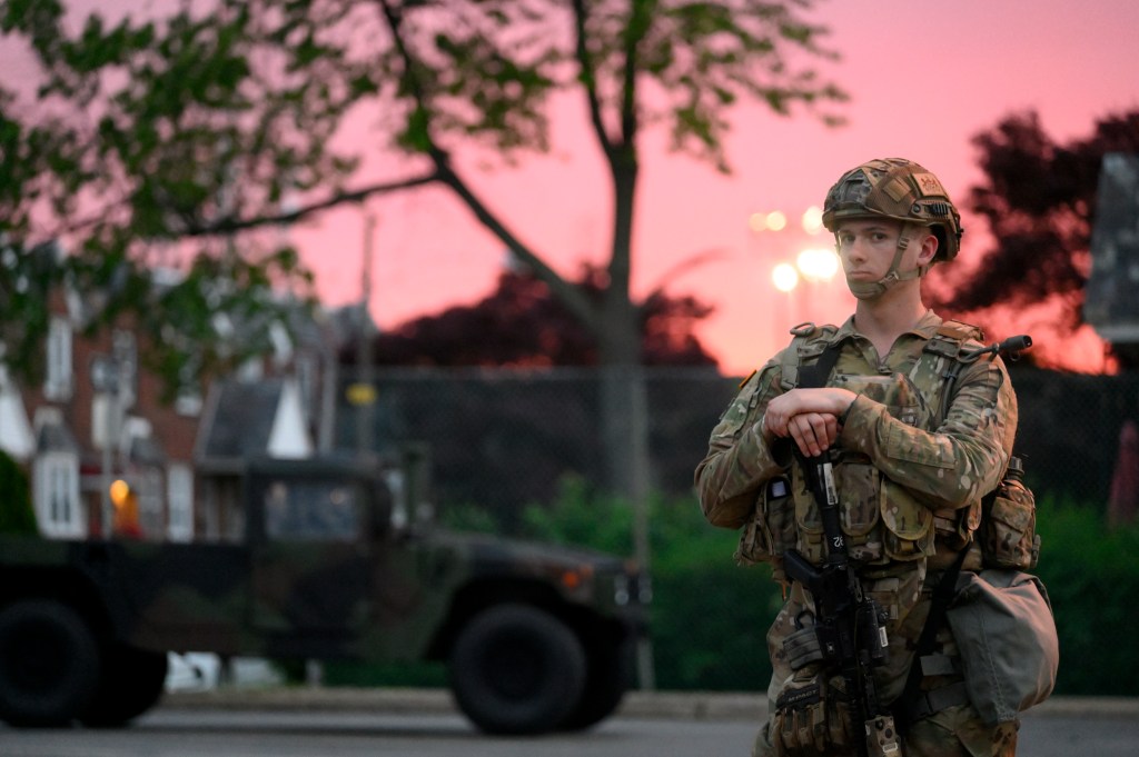 National Guardsmen assist police officers with guarding local businesses recently hit by looters, in the Wadsworth/Mt Airy neighborhood in Philadelphia, on June 3, 2020.