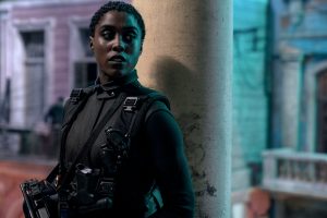 007-Darstellerin Lashana Lynch steht in Kostüm vor einer Säule