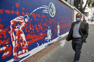 A man walks past graffiti on the walls of the former Tehran Embassy building.