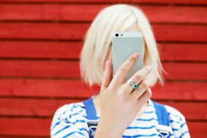 Young woman takes selfie with phone in front of her face