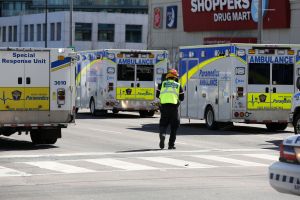 Police officers stand near several ambulances after a truck hit several pedestrians in Toronto, Ontario, on on April 23, 2018